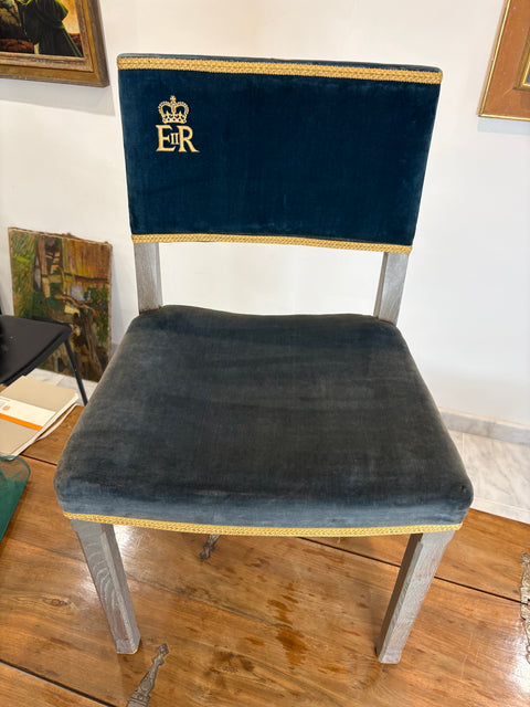 Chair with blue velvet seat and backrest on a wooden floor.