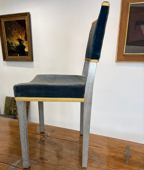 Chair with black cushion and gold trim in an art gallery setting